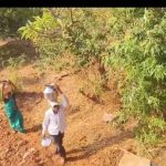 आदिवासी महिला धाडसी डोंगराच्या पायथ्याशी पाण्यात चालत पडण्याचा धोका पत्करतात